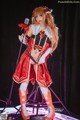 A woman in a red and white outfit holding a microphone.