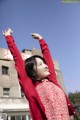 A young girl in a red dress and a red cardigan.